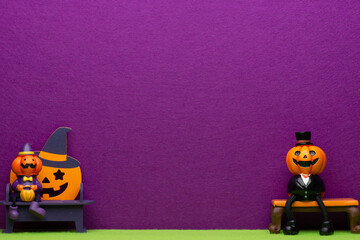 ハロウィンの飾りと紫のフェルトの背景