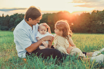 Happy family father with children daughter and baby boy on nature sunset