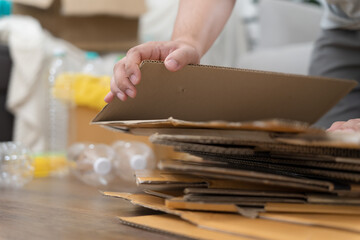Obraz premium Home recycle eco zero waste concept Man using recycle paper box. Stacking brown cardboard box eco friendly packaging made of recyclable raw materials.