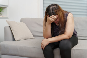 Sad Overweight plus size woman thinking about problems on sofa upset girl feeling lonely and sad...
