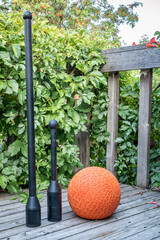 adjustable weight steel club,  mace and a slam ball on a wooden backyard deck, functional fitness...