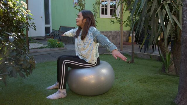 adolecente se ejercita en pelota de pilates