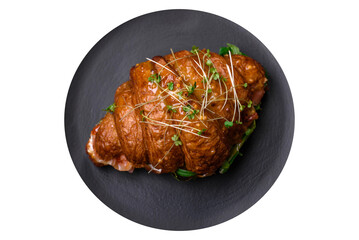 Delicious crispy croissant with salmon, lettuce, cheese and tomatoes