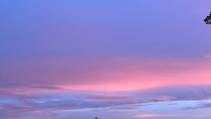 clouds tinted brilliant hues of orange and pink by setting sun.