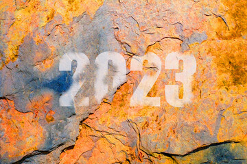 White text of  year  two thousand twenty three on rustic stone wall