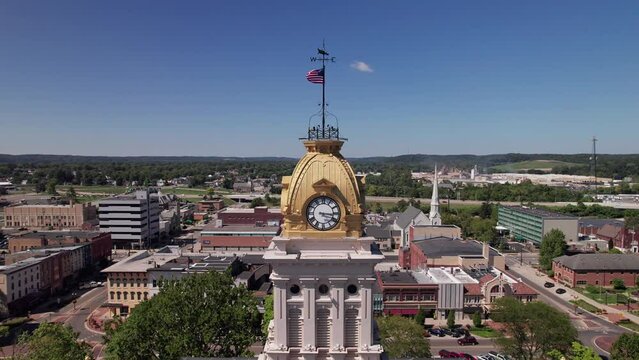 Aerial view and drone shot of clocktower government tower and building structure in the center of Newark, Ohio east of Columbus, OH with downtown buildings, small businesses, and residential district.