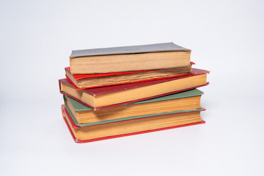 Old antique novels, colour-bound books with white backgrounds, vintage books with isolated straw paper, notebooks stacked on top of each other, concept, literature textbook photo idea.