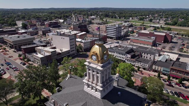 Aerial view and drone shot of clocktower government tower and building structure in the center of Newark, Ohio east of Columbus, OH with downtown buildings, small businesses, and residential district.