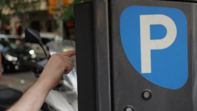 Man tourist paying for a parking ticket on the street of Spain, Barcelona, automatic city car and bike parking payment.