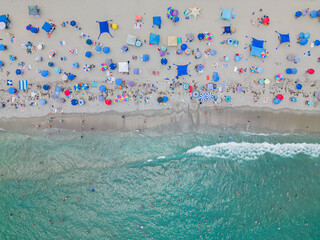 Aerial top-down photo of a busy day at the beach with waves.