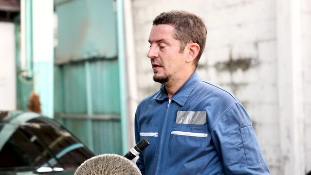 Senior middle aged Caucasian man exhausted tired feeling hot or sick hand wipe sweat stand in auto painting services room in garage, health care for elderly people working in windless area or work har