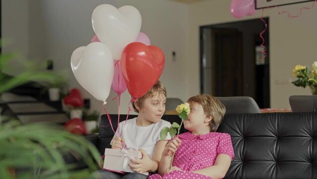 Boy and girl are in the decorated room for Valentine's Day