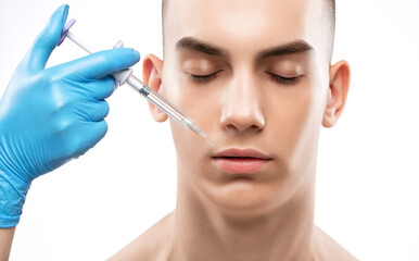 Naklejka premium Men's cosmetology. Beautician makes a rejuvenation injection procedure on the face of a young man.