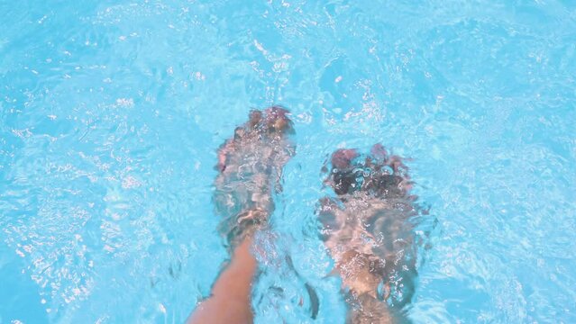close up legs feet sole in pool water. summer time vacation. girl woman or baby kid child feet 4k sunny