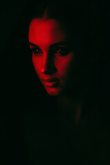 Portrait of an attractive girl with healthy clean skin and beautiful makeup in red and black. Aesthetic cosmetology and make-up concept.