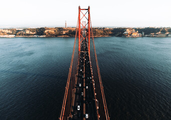 Aerial photos of the 25 April bridge (Ponte 25 de Abril) located in Lisbon, Portugal, crossing the Targus river - taken by drone. - obrazy, fototapety, plakaty