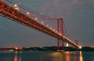 Image of the 25 April bridge (Ponte 25 de Abril) located in Lisbon, Portugal, crossing the Targus river at night.
