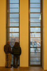 Obraz premium Two persons looking at the Thames river from the windows of a modern building in Central London.