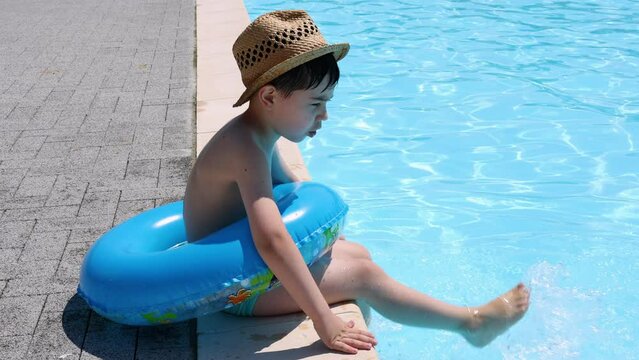 kid on poolside.sibling playing with legs in pool water,summer vacation time. dad kissing little child.baby boy in beach hat 4k 