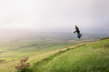 A man jumping on top of a mountain