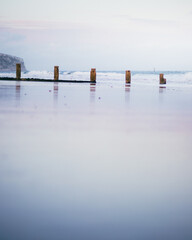 Groynes in the wet sand at the beach