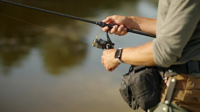 Fisherman catching perch fish in river	