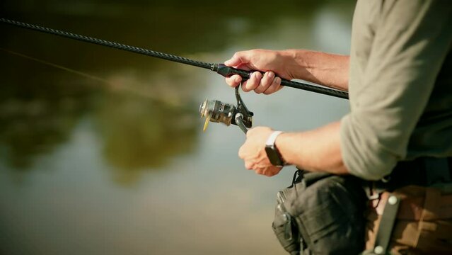 Fisherman catching fish perch on river	