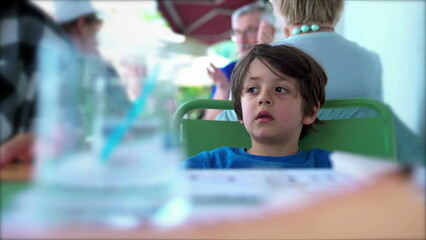 Child at Restaurant Lost in Thought, Staring at Horizon with Pensive Gaze, Reflecting on Thoughts