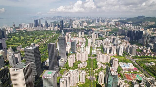 Drone flight above Shenzhen city metropolis, China's innovative, technology hub.
Aerial footage of the financial centre modern skyscrapers surrounded by beautiful green hills