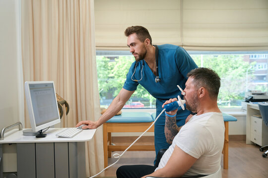 Pulmonologist monitoring patient lung function during spirometry test