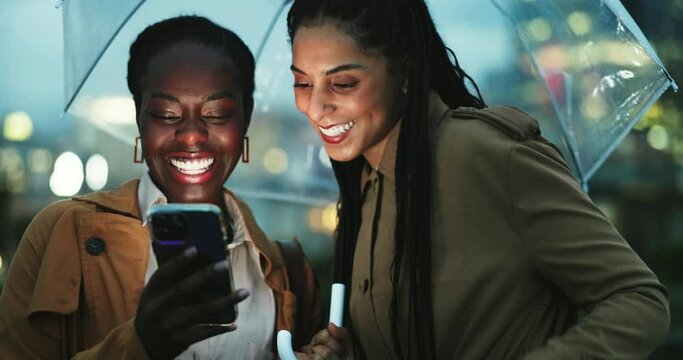 Women friends at night, smartphone and umbrella in city, travel and insurance, ride share app and laugh. Commute, funny meme on social media and using phone to call taxi, security in winter and rain