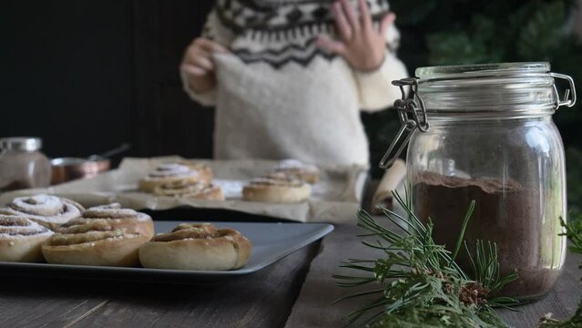 Mother and son eating baked Swedish Cinnamon Buns on table at home
