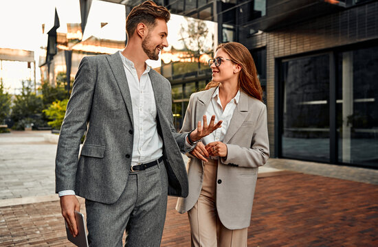 Building the future together! Two young beautiful successful professionals business partners are walking and discussing work on the street. Business lifestyle, on the way to the conference.