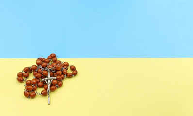 Pray for Ukraine. A Christian rosary on the Ukrainian flag