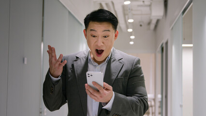 Happy surprised Asian mature man emotional winner male chinese korean businessman smiling...