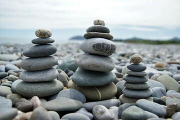 Fototapeta na wymiar Towers made of pebbles. Three Zen towers on a stony beach.