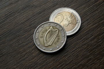 Irish 2 euro coins. Used coins on a dark wooden table