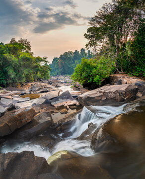 Maak Ngaew Waterfalls and cascades running through tropical forest,at sunset, near Pakse,Laos.