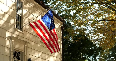 American flag hangs from a clapboard house