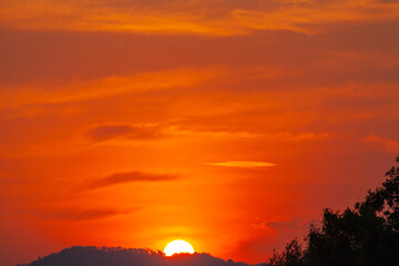 exotic The big sun in red sky at sunset. Gradient color..Sunset with bright red light rays..amazing red sky.phone antenna post. .