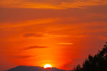 exotic The big sun in red sky at sunset. Gradient color..Sunset with bright red light rays..amazing red sky.phone antenna post. .