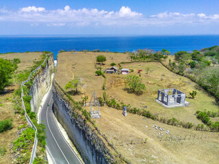 A high angle drone photo of the road between cliffs at Pandawa Beach in Bali offers a breathtaking perspective of this scenic coastal route.