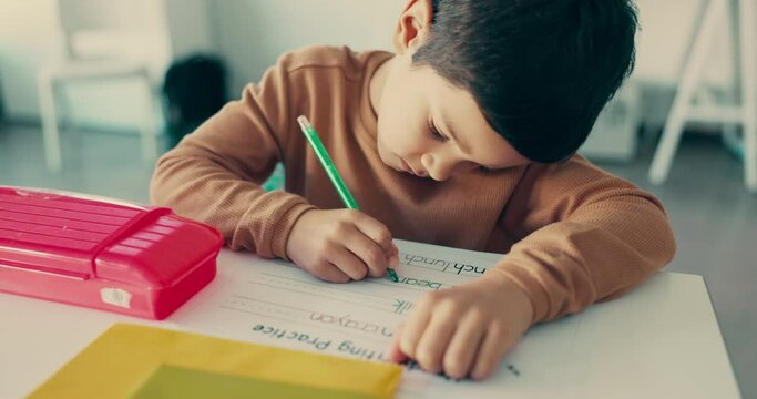 Boy child, education and student writing in classroom with learning, knowledge and academic growth. Activity, studying and lesson, paper with test and letters, alphabet at school with development