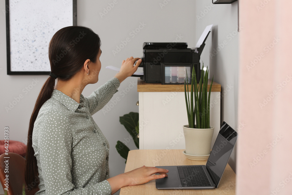 Canvas Prints Woman using modern printer at workplace indoors