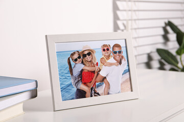 Frame with family photo on white table indoors, closeup