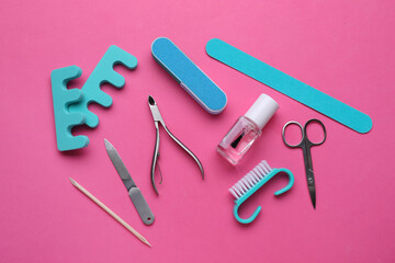 Set of pedicure tools on pink background, flat lay