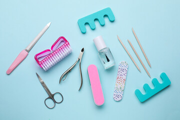 Set of pedicure tools on light blue background, flat lay