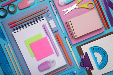 Flat lay composition with notebooks and other school stationery on light blue background. Back to...