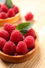 Tartlet with fresh raspberries on wooden table, closeup and space for text. Delicious dessert