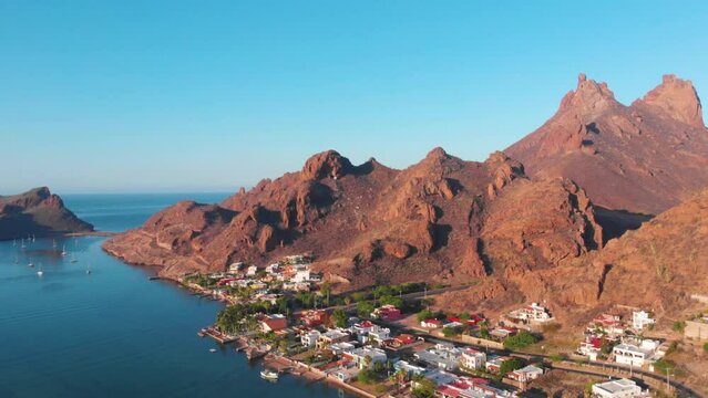 Toma de dron de casas en la orilla de la playa con el cerro del Tetakawi de fondo